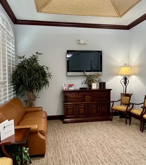 Seating in the lobby, a leather sofa and cane-back chairs.